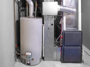 A residential basement with a water heater tank on the left and a furnace with ductwork on the right, showing typical home heating and hot water equipment.